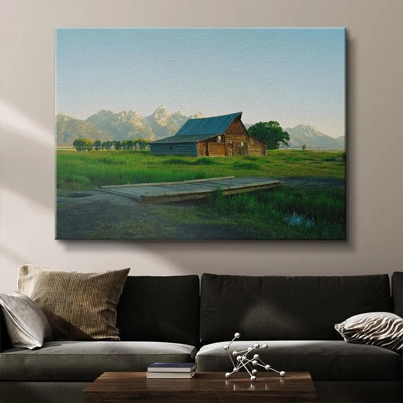 Atmospheric shot of the snow-capped Teton peaks towering over the rustic Jackson Greens structure at sunrise.