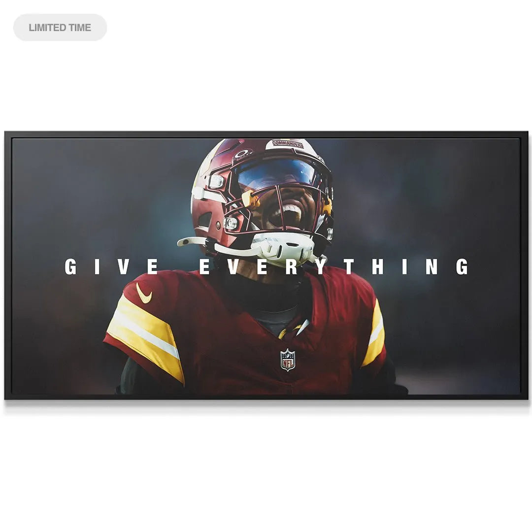 Lifestyle shot of the large format canvas print Jayden Daniels - Give Everything hanging above a modern sofa.