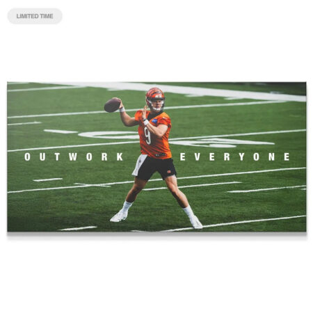 Full wide shot of Joe Burrow - Outwork Everyone throwing the football over the yard lines on the green field.