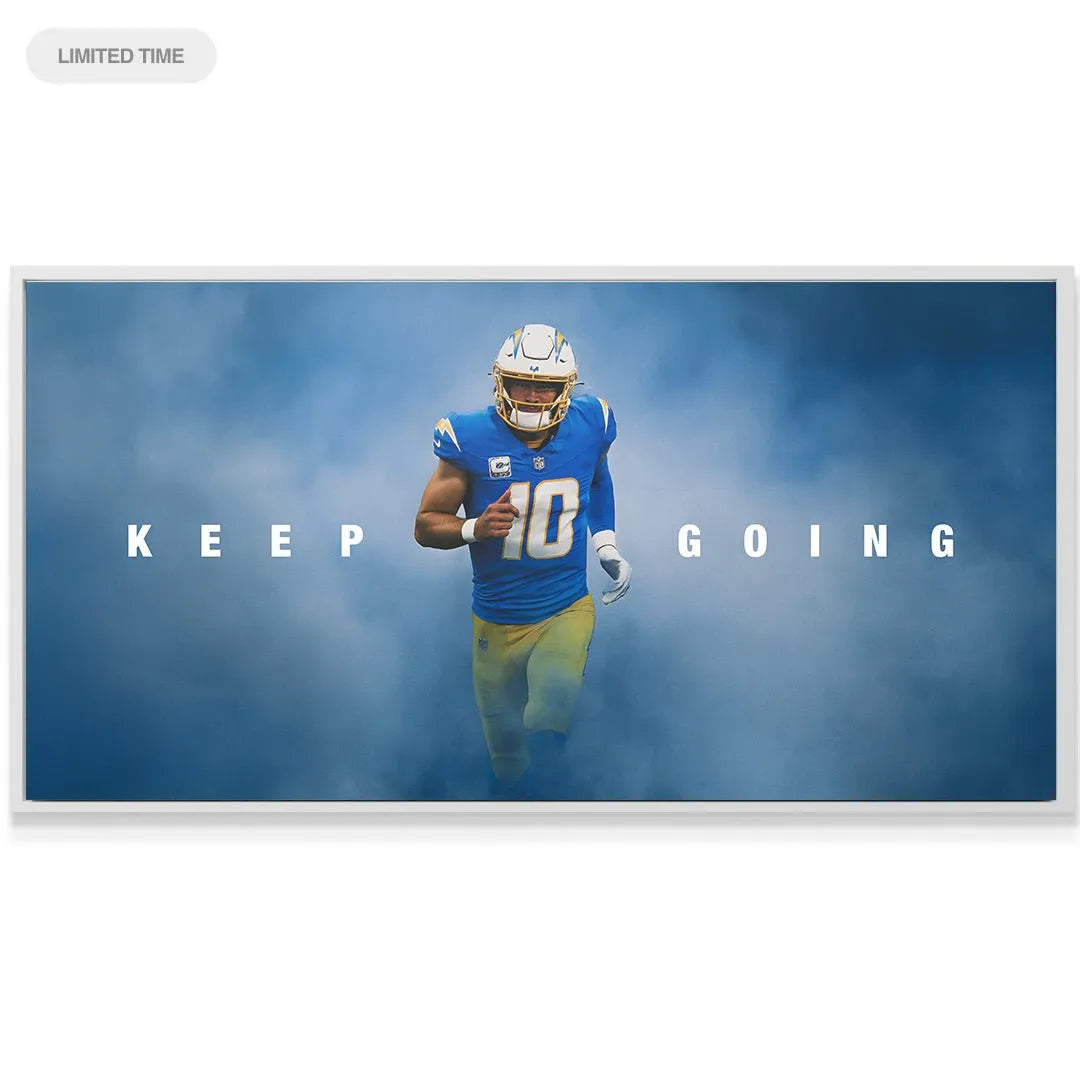 Lifestyle shot of the 'Justin Herbert - Keep Going' artwork mounted above a modern desk setup, showcasing its size relevance.