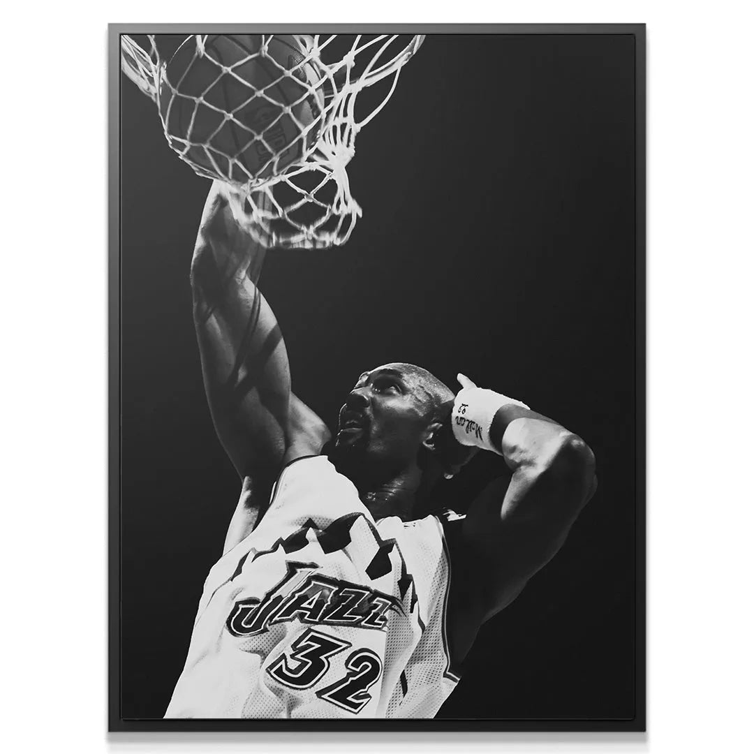 Dynamic, low-angle view of Karl Malone - #1 completing a powerful black and white slam dunk.