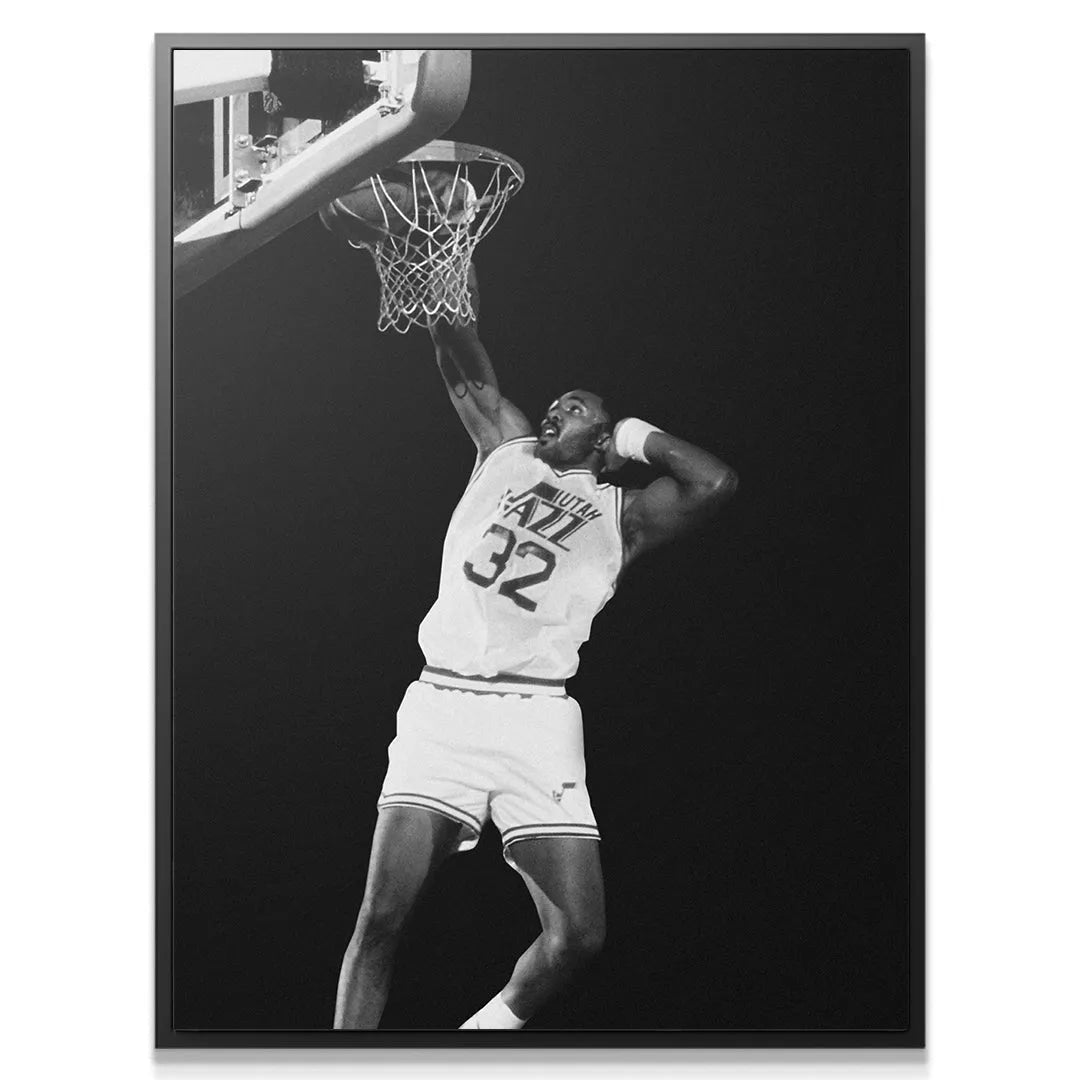 Full vertical shot of Karl Malone - #2 slamming the basketball in the black and white Utah Jazz uniform.