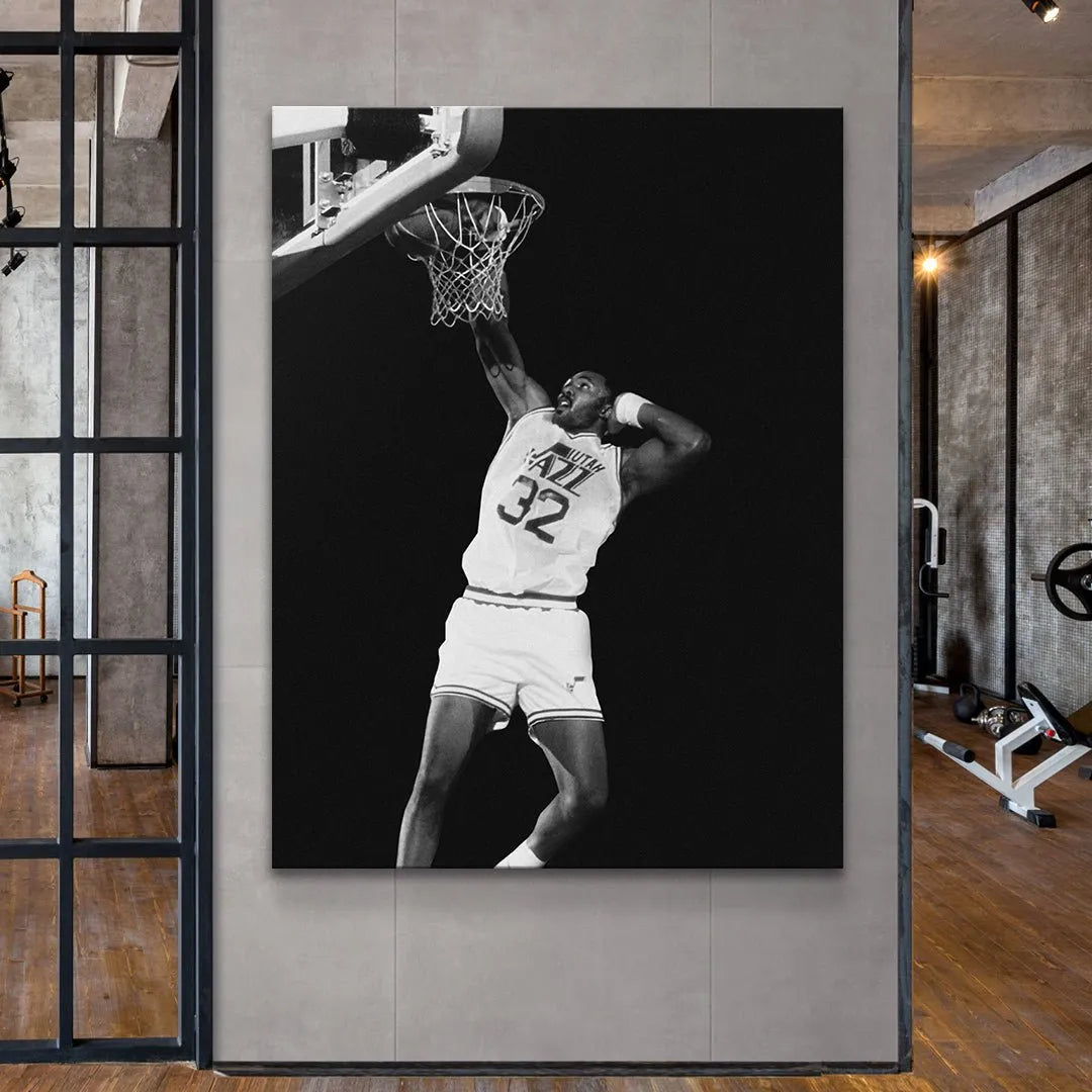 Low-angle perspective photograph of Karl Malone - #2 soaring above the rim against a dark background.