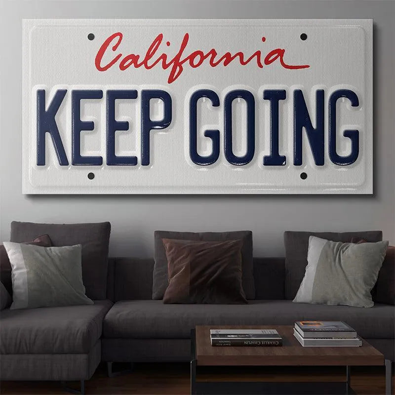 Lifestyle photo showing the 'Keep Going - CA' plate mounted on a rustic wooden wall.
