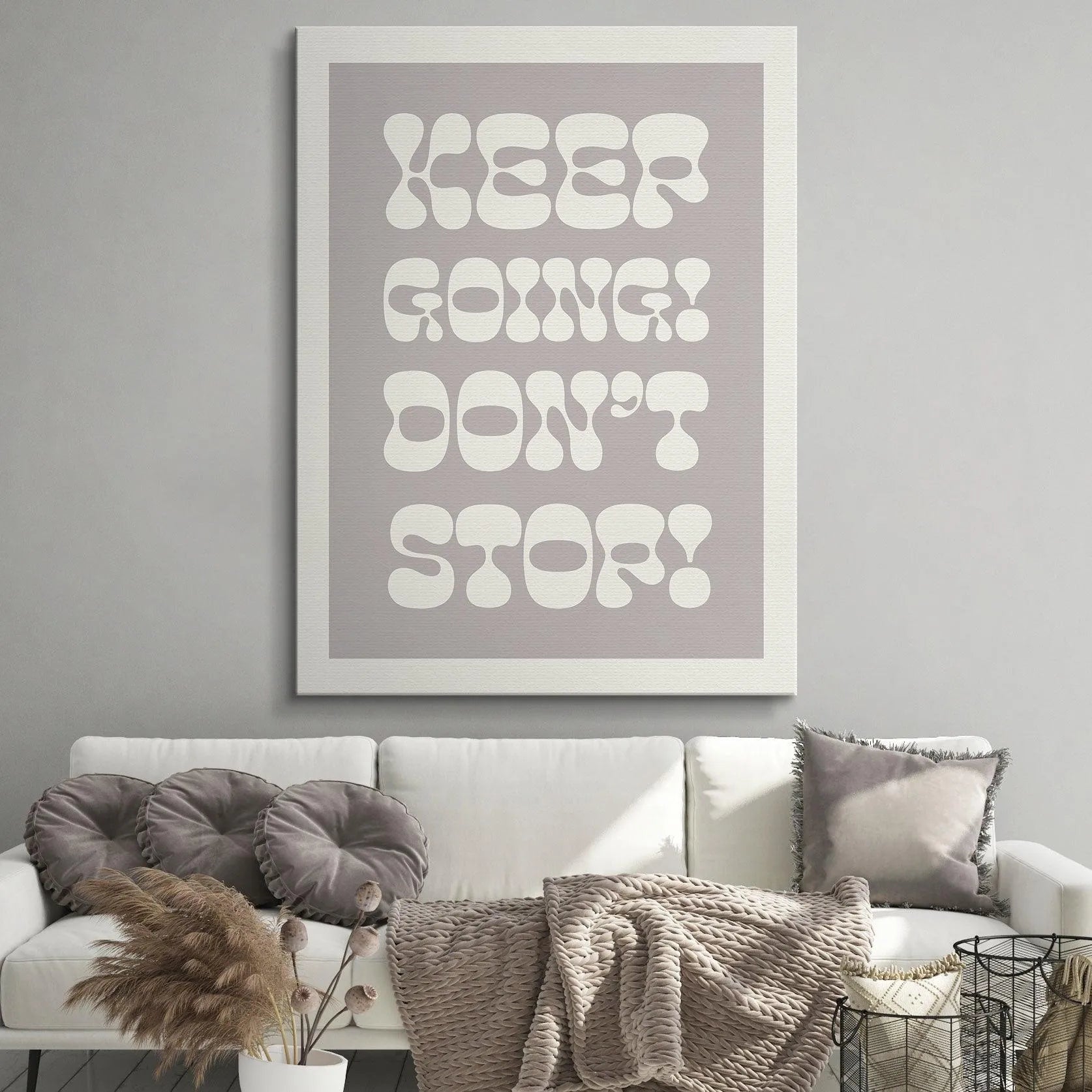 Lifestyle photo: 'Keep Going! Don't Stop!' poster hanging above a minimalist wooden desk setup for home office inspiration.