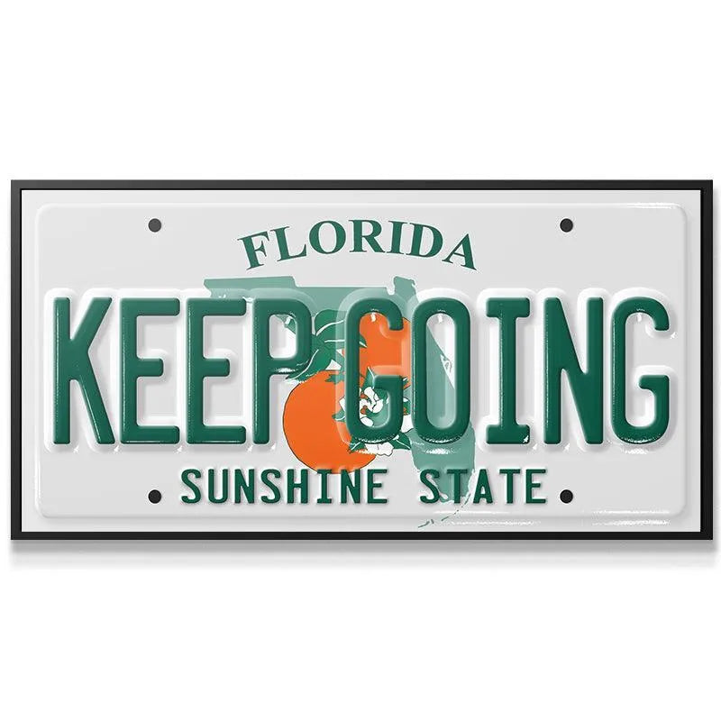Close-up of the raised green "KEEP GOING" text on the Keep Going - FL plate detail.