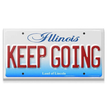 Close-up view of the embossed red "KEEP GOING" text on the novelty Illinois license plate, Keep Going - IL.