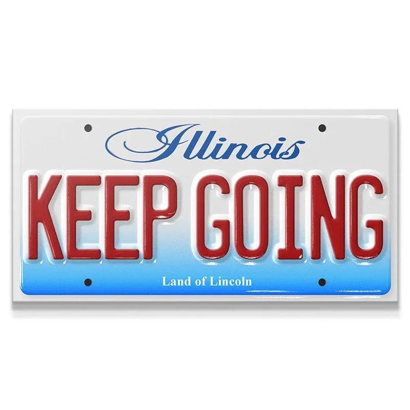 Close-up view of the embossed red "KEEP GOING" text on the novelty Illinois license plate, Keep Going - IL.