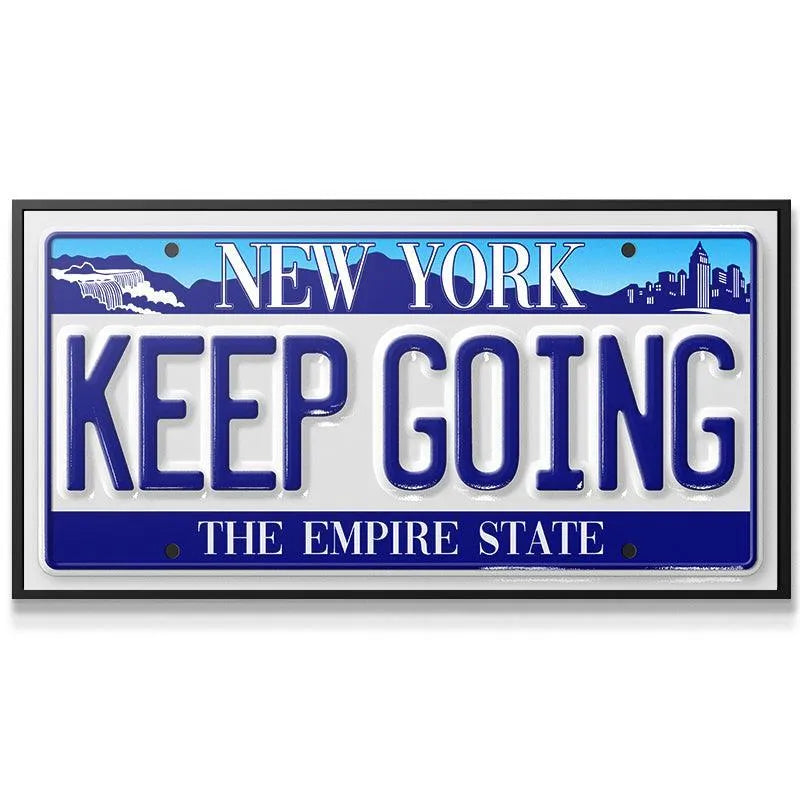 Close-up detail of the raised blue lettering showing the texture of the "Keep Going - NY" plate.