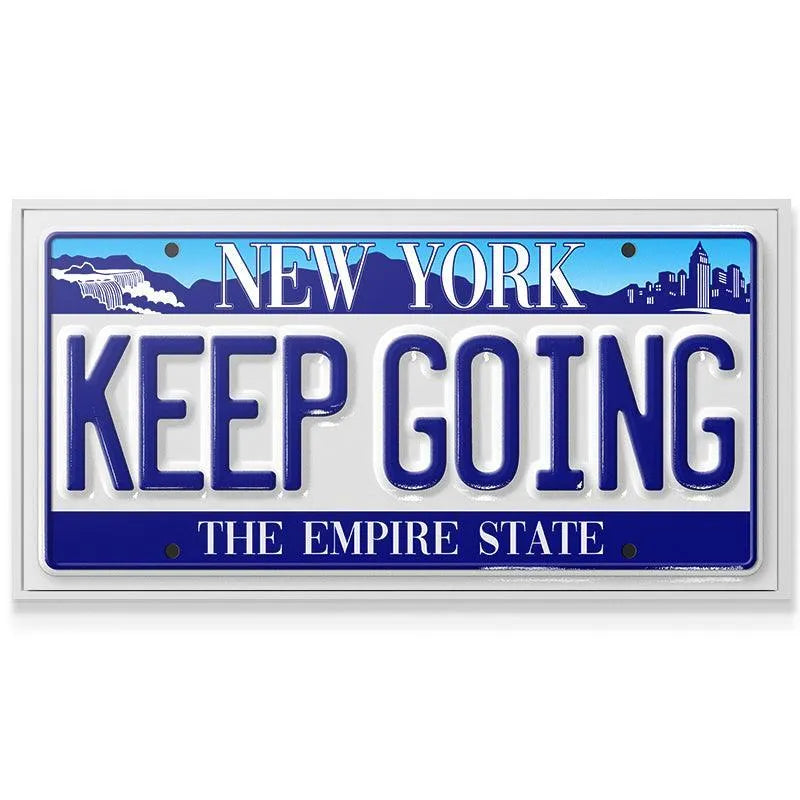 Angled shot highlighting the metallic shine and reflective qualities of the "Keep Going - NY" souvenir sign.