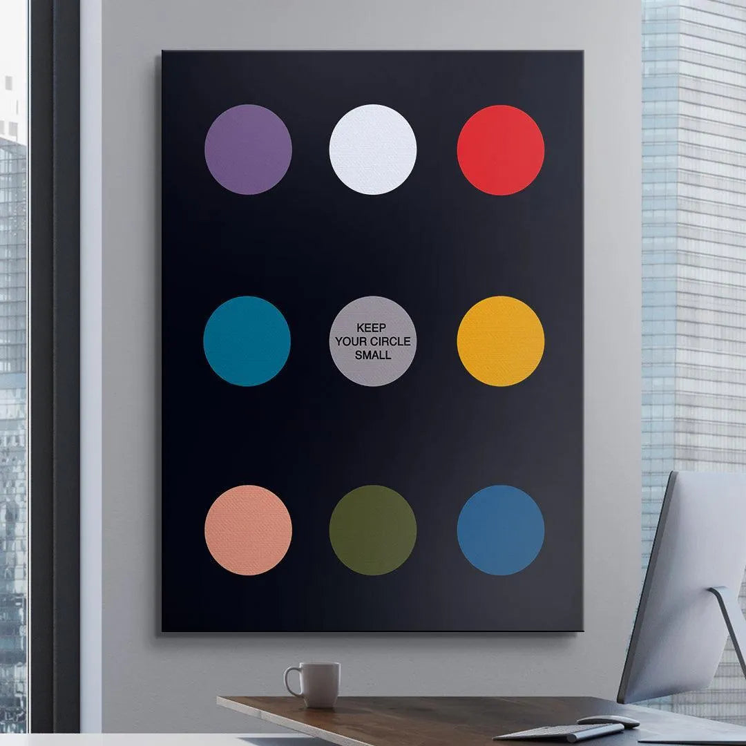 Lifestyle image of the framed Keep Your Circle Small Black Edition art hanging above a minimalist home office desk setup.