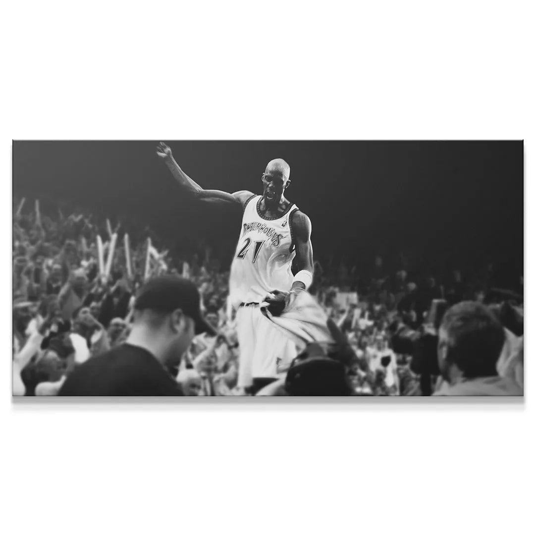 Wide-angle black and white stadium shot of Kevin Garnett - #2 raising his arm in victory.