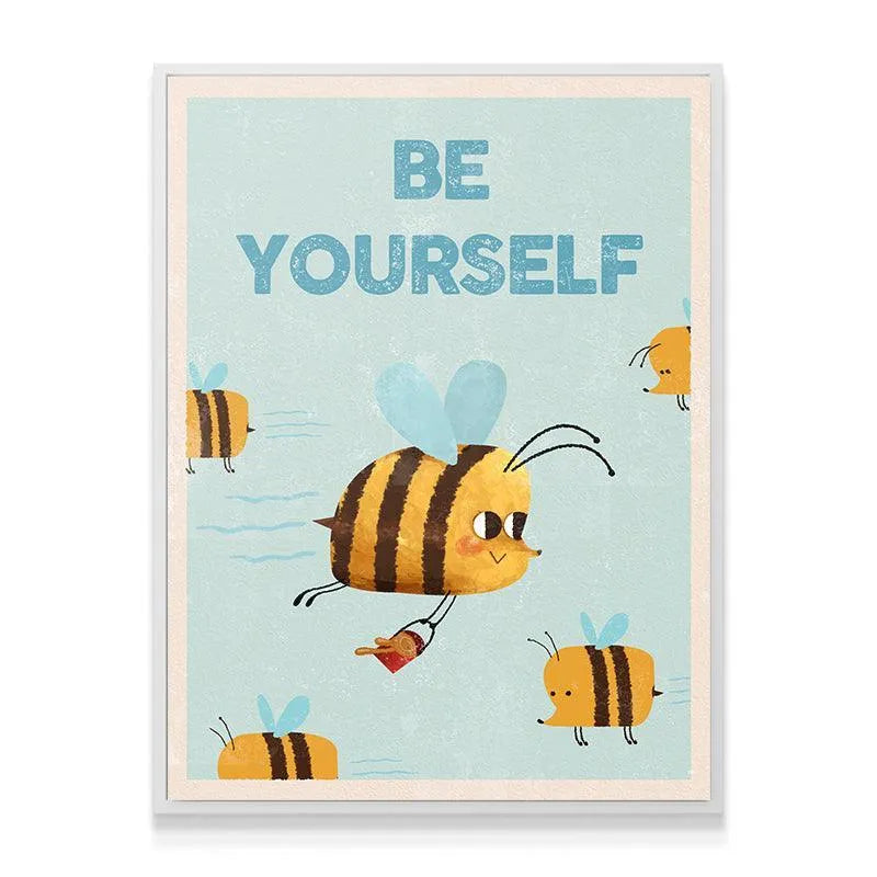 Angled view of the Kids Be Yourself print mounted in a natural wooden frame ready for a child's room display.