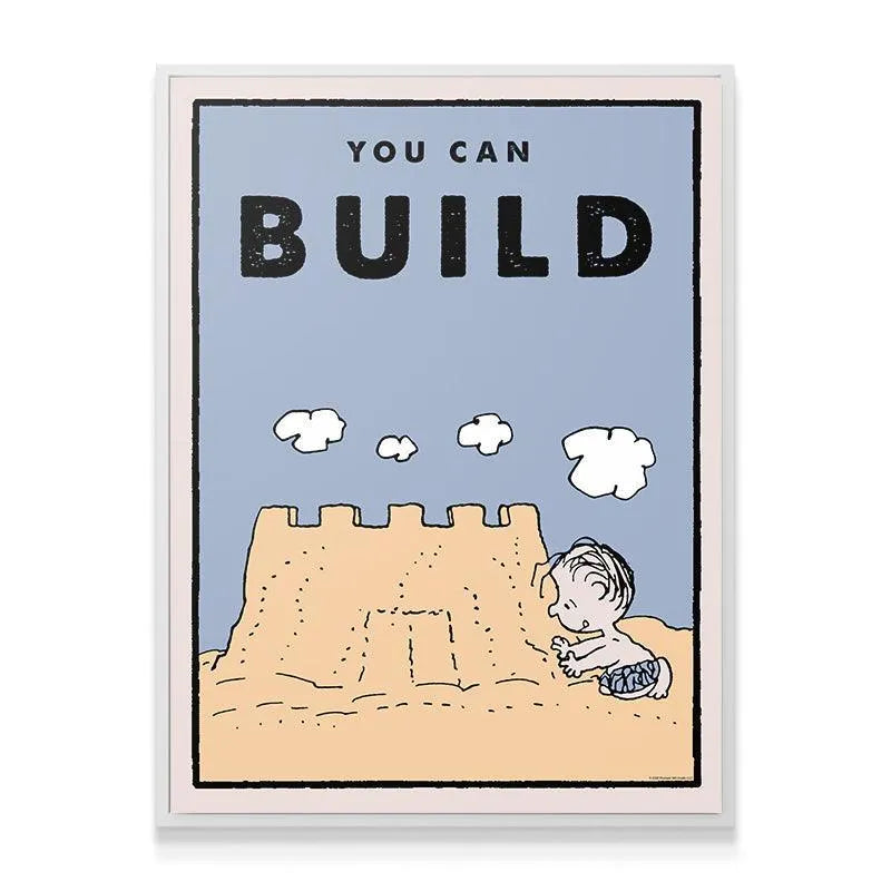 Lifestyle shot of the motivational 'Kids PEANUTS - You Can Build' artwork hanging above a child's wooden desk.