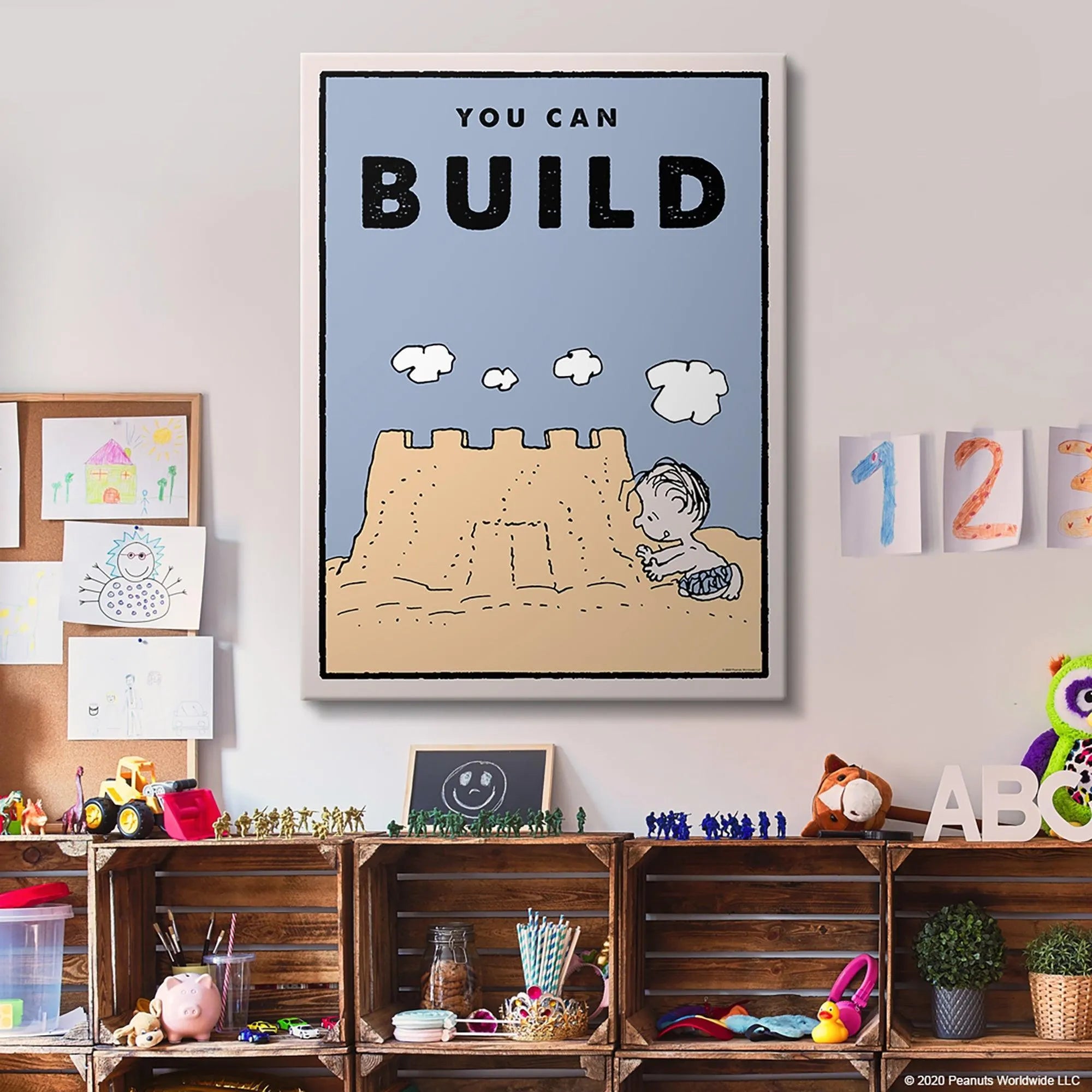 Corner perspective highlighting the thick border and pale blue sky of the 'Kids PEANUTS - You Can Build' inspirational poster.
