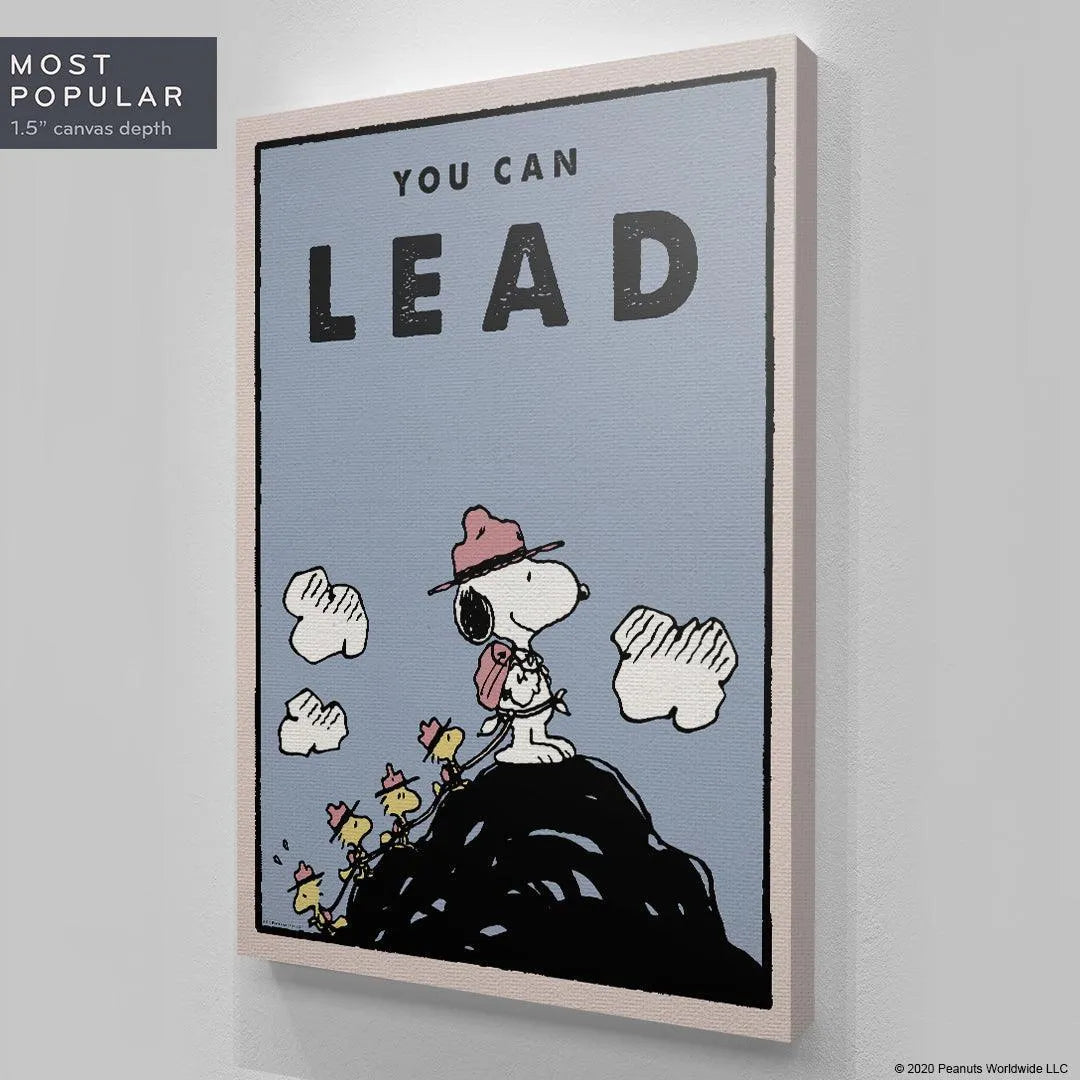Lifestyle shot of the framed Kids PEANUTS - You Can Lead poster hanging prominently in a child's bedroom.