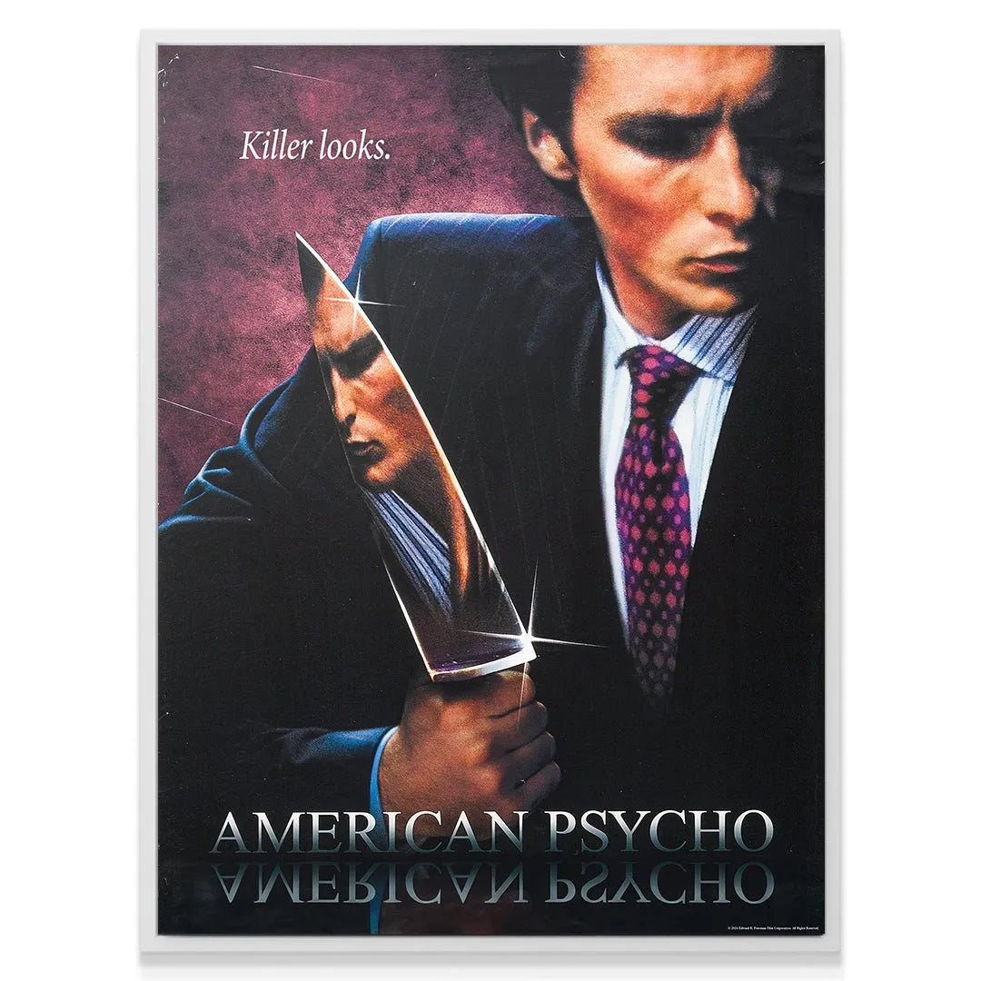 A tight view focusing on the mirrored reflection of Bateman's second, darker face on the knife blade, emphasizing the 'Killer Looks' duality.