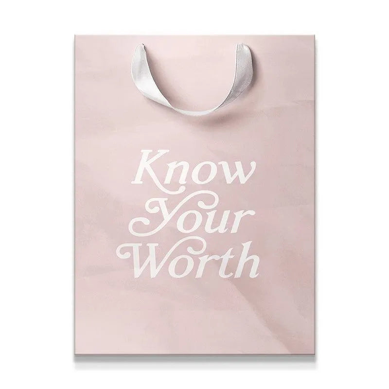 Full view of the blush pink gift bag featuring the 'Know Your Worth' script print.