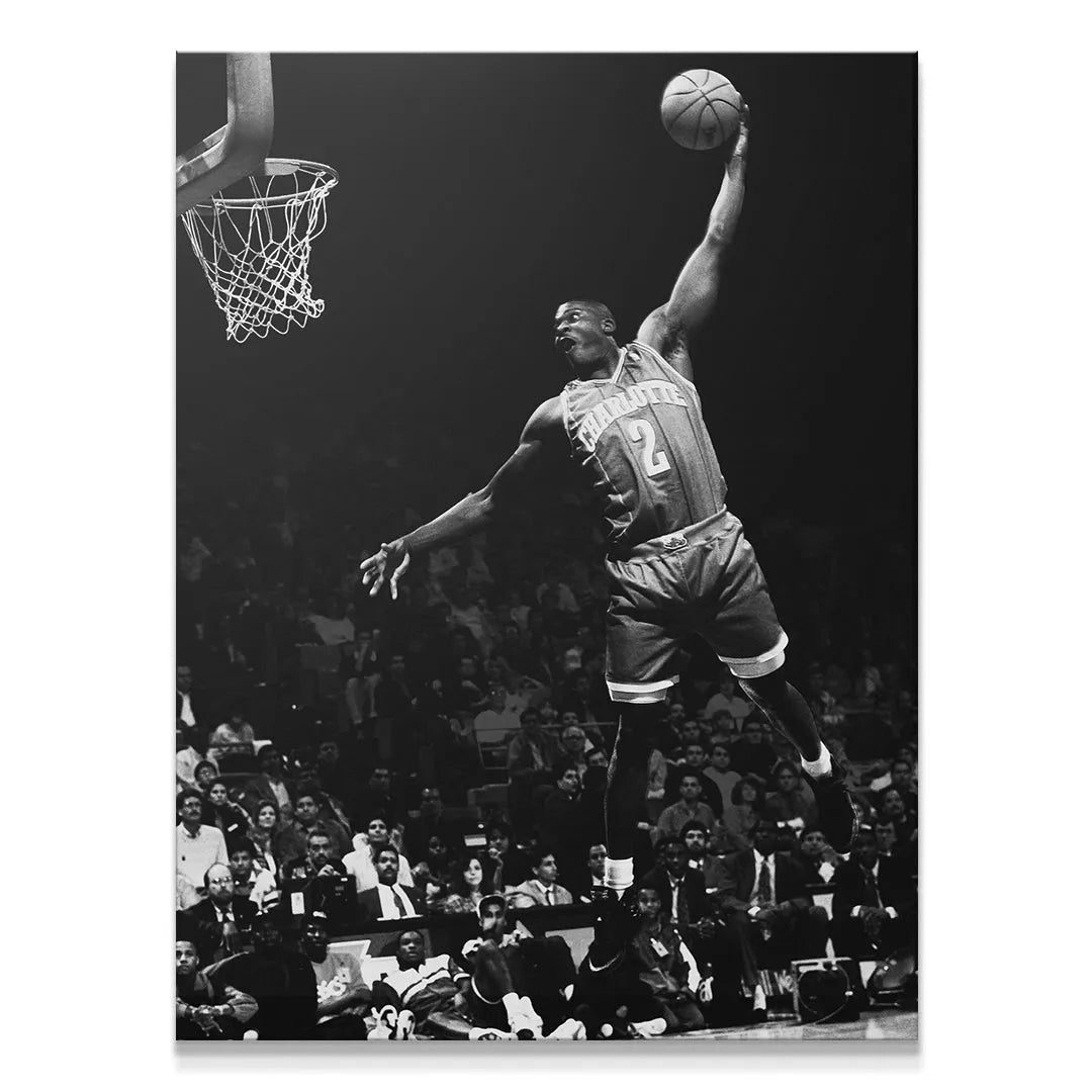 High-contrast black and white action shot of Larry Johnson - #1 executing a ferocious dunk over the crowd.