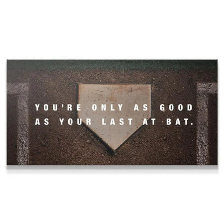 Overhead view of the worn home plate featuring the 'Last At Bat' motivational quote centered on the dirt.
