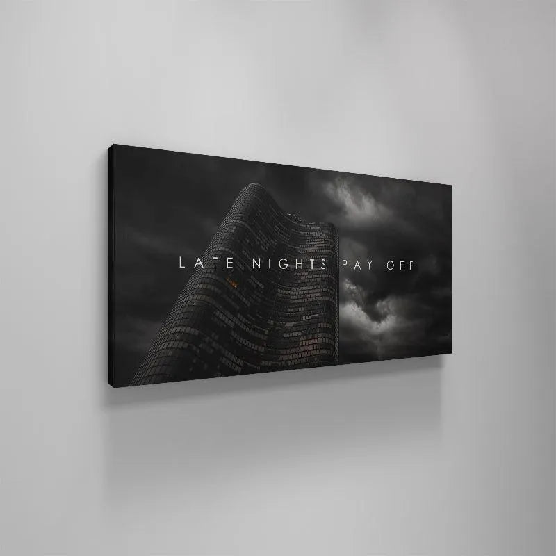 Lifestyle depiction of the 'Late Nights Pay Off' print mounted above a large, dedicated home workspace desk for inspiration.