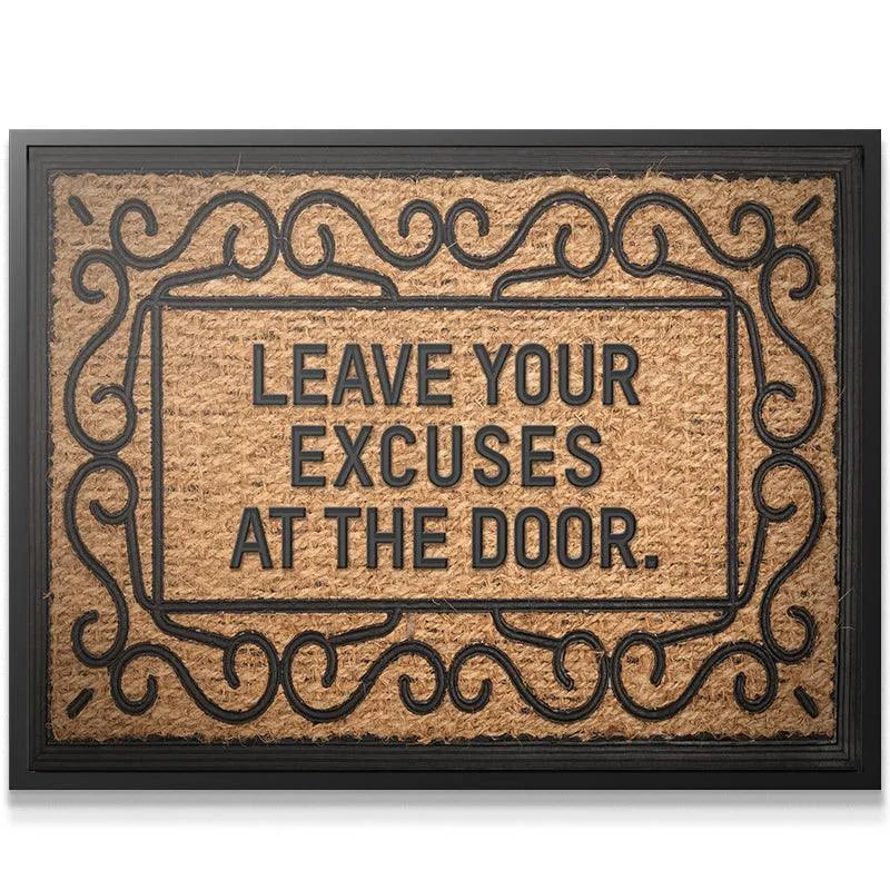 Close-up shot of the bold, black raised lettering spelling out "Leave Your Excuses At The Door" on the mat.