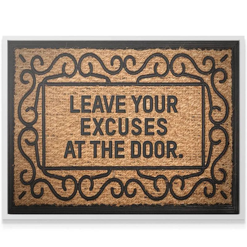 Corner detail of the elegant black scrollwork border surrounding the "Leave Your Excuses At The Door" coir mat.