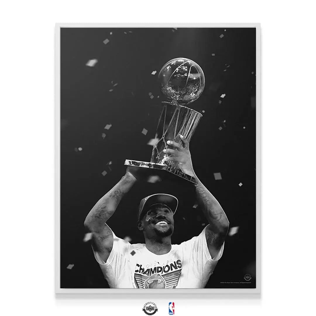 Upward angle shot of LeBron James - The First raising the trophy against a dark, dramatic background.