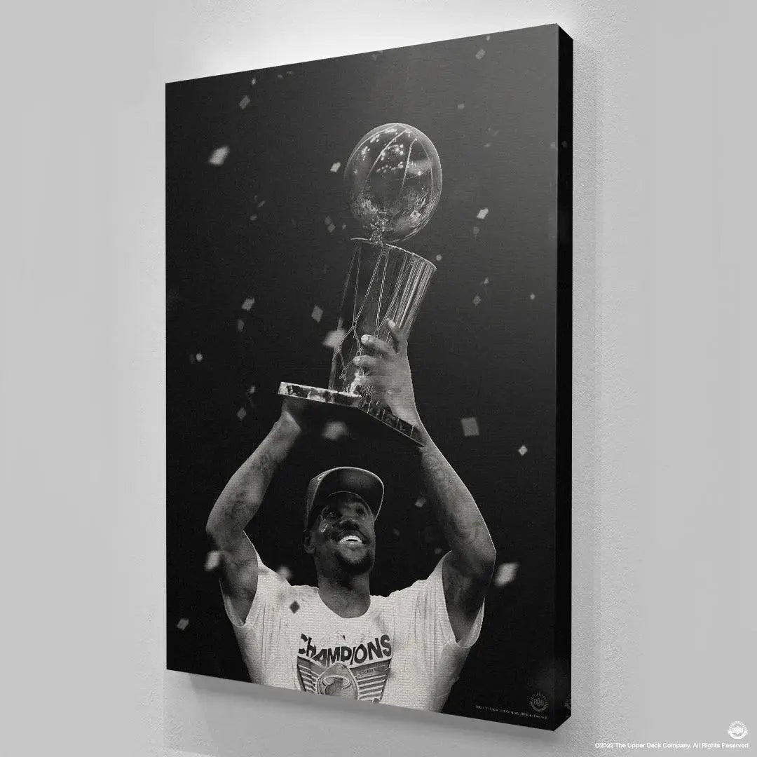 Detailed view of the hands of LeBron James - The First gripping the base of the championship trophy securely.