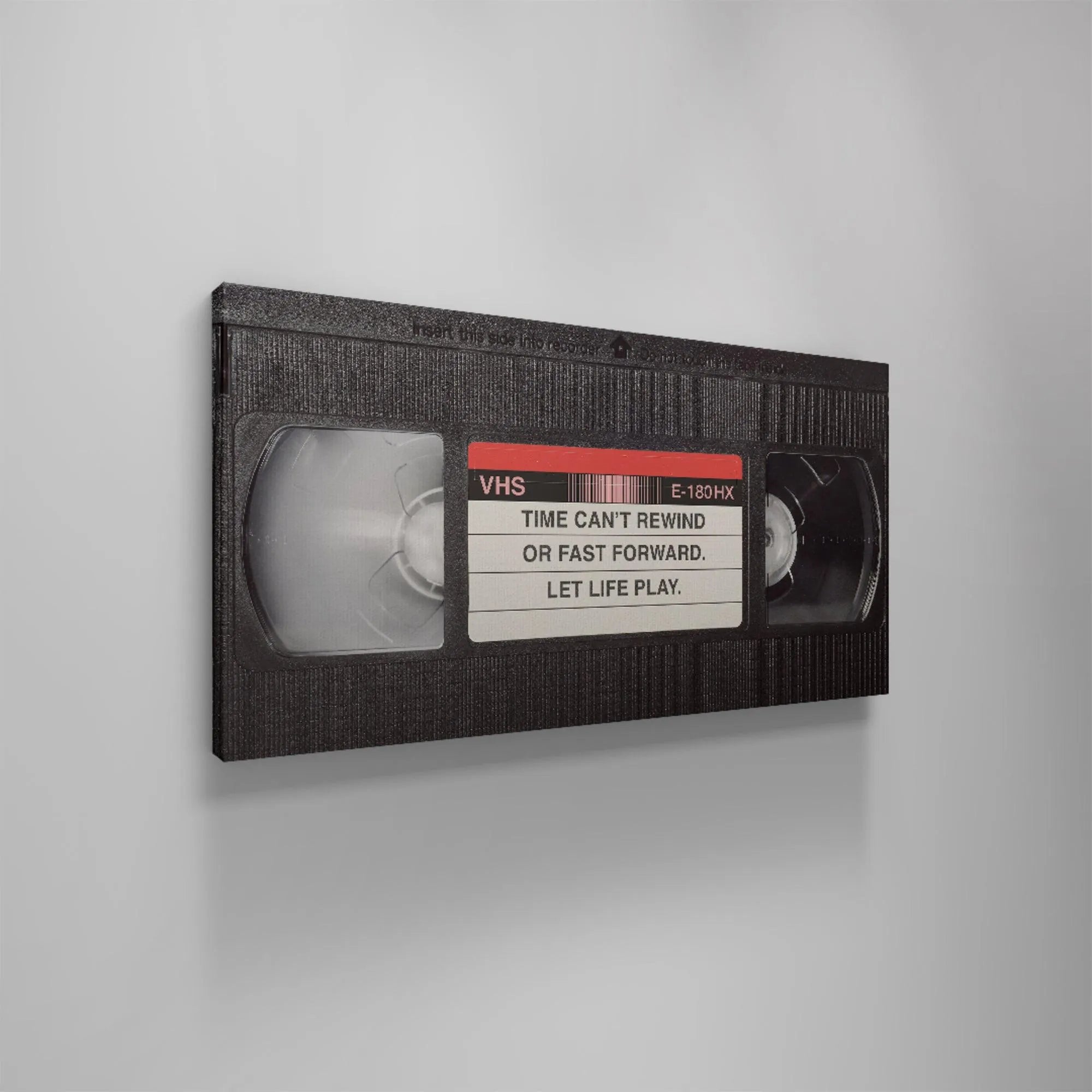 Macro shot of the VHS label showing the E-180 HX identifier and the core phrase: 'Let It Play'.