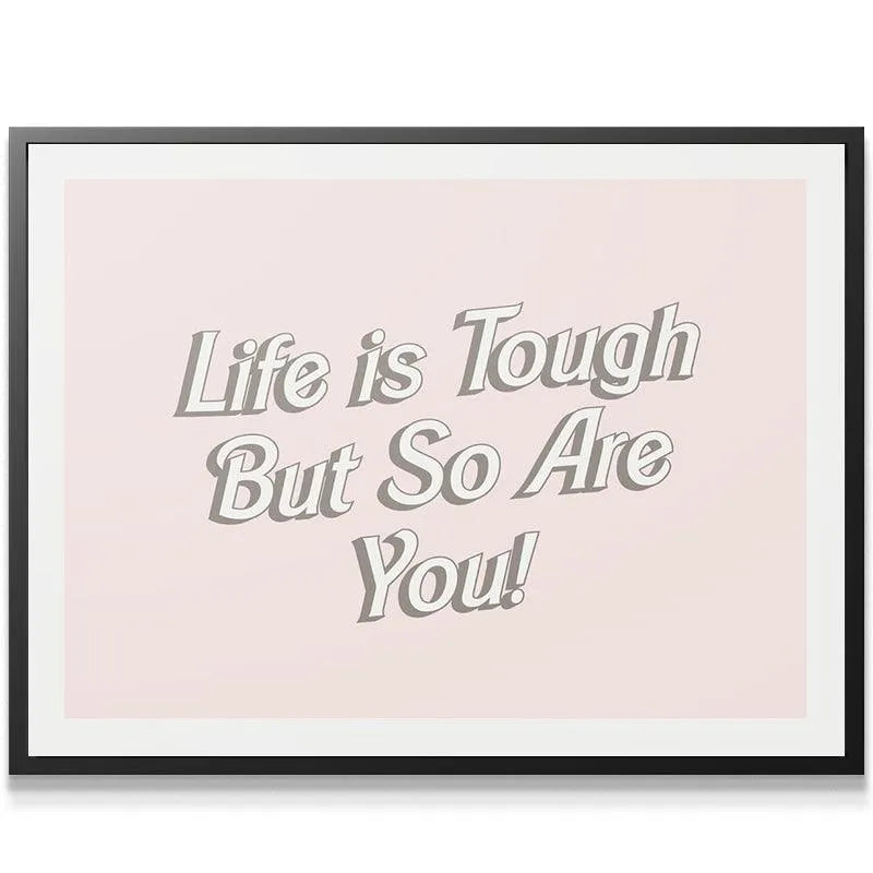 Lifestyle image of the blush pink print 'Life is Tough' framed beautifully in a bright modern home office setting.