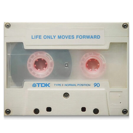 High-angle view of the TDK cassette wall art featuring the quote 'Life Only Moves Forward' in blue typography.