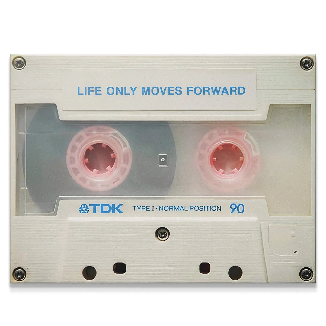 High-angle view of the TDK cassette wall art featuring the quote 'Life Only Moves Forward' in blue typography.