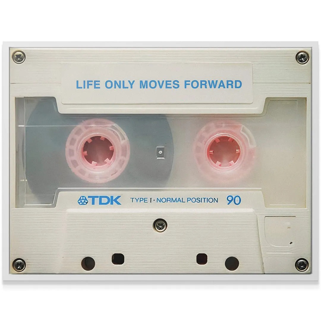 Textured shot of the off-white cassette casing surface with visible screws, highlighting the message 'Life Only Moves Forward'.