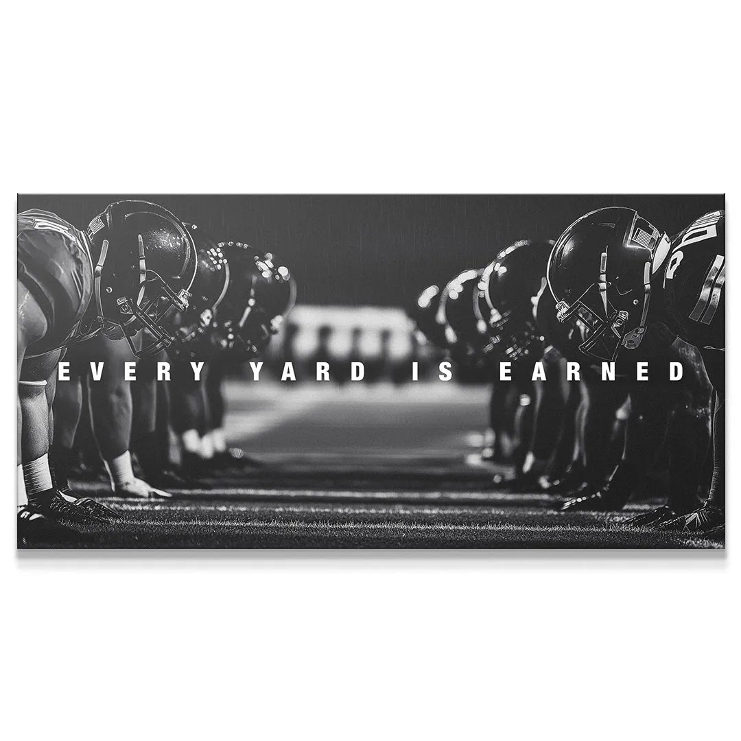 Close-up view of crouched linemen helmets at the line of scrimmage with text 'Linemen - Every Yard Is Earned'.