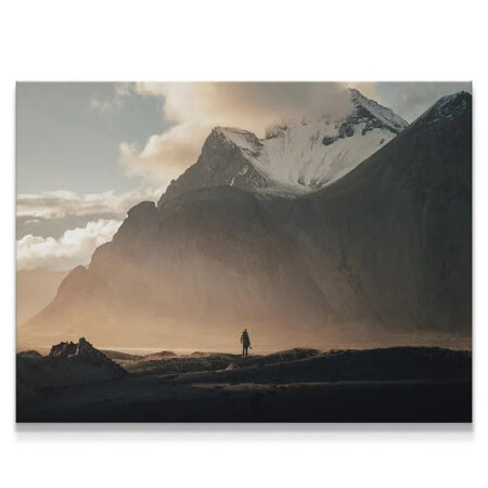 Wide shot of the vast snow-capped Icelandic mountain range featuring the tiny traveler in the 'Lonely Stokk' print.