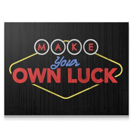Full view of the distressed black wall art featuring the phrase Make Your Own Luck in neon red and yellow typography.