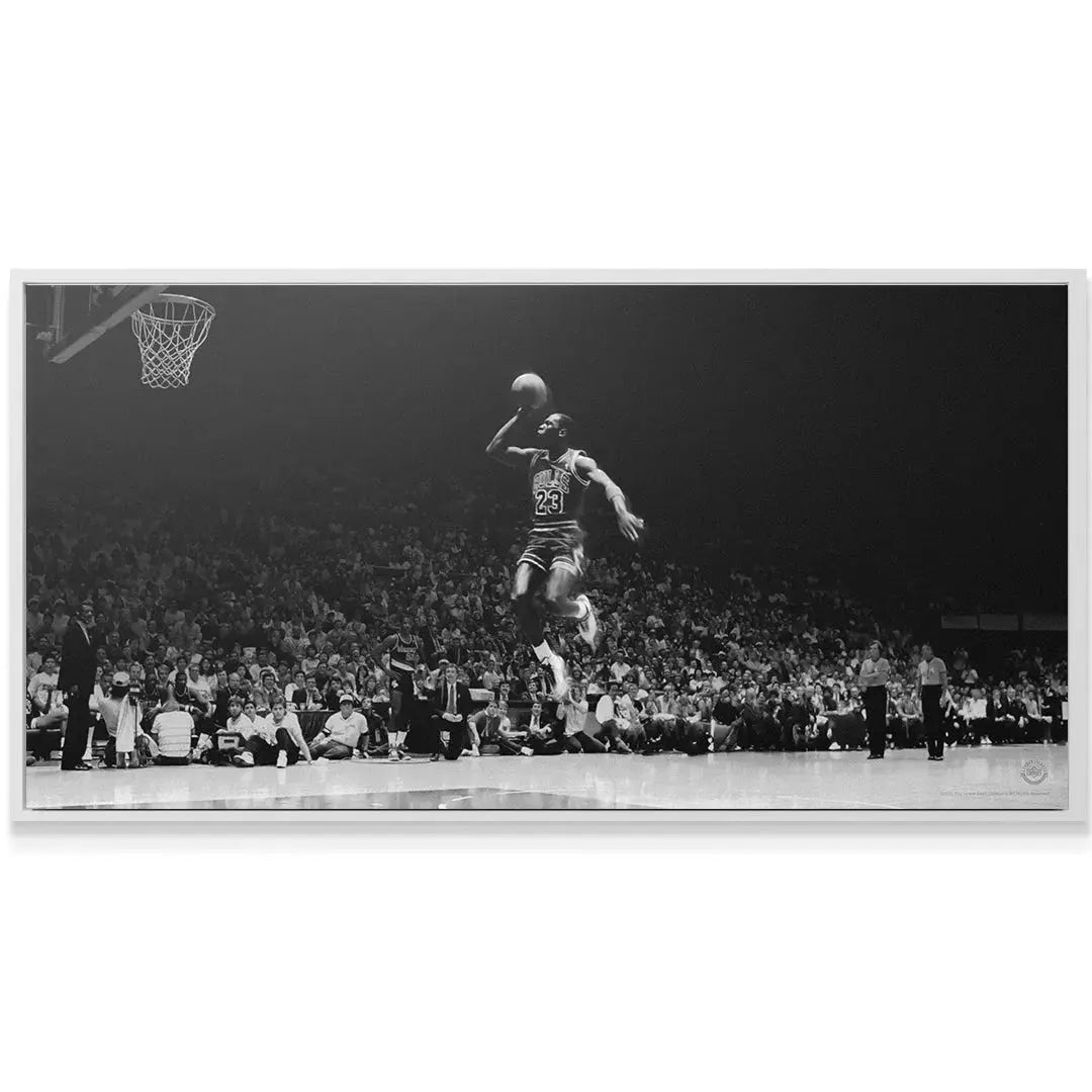 Dramatic low-angle view of Michael Jordan - Elevation emphasizing his soaring height above the court surface.