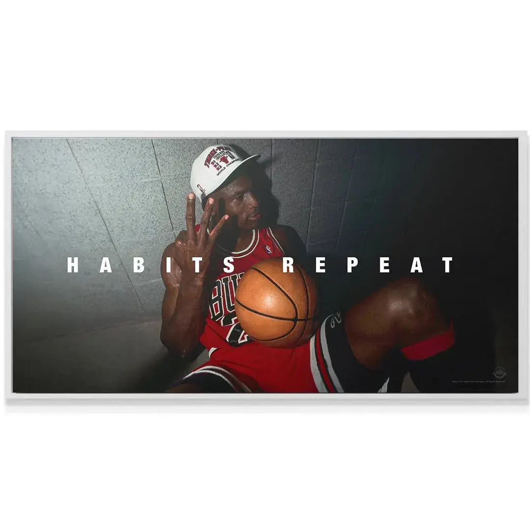 Lifestyle shot of the framed 'Michael Jordan - Habits Repeat' poster hanging in a modern office.