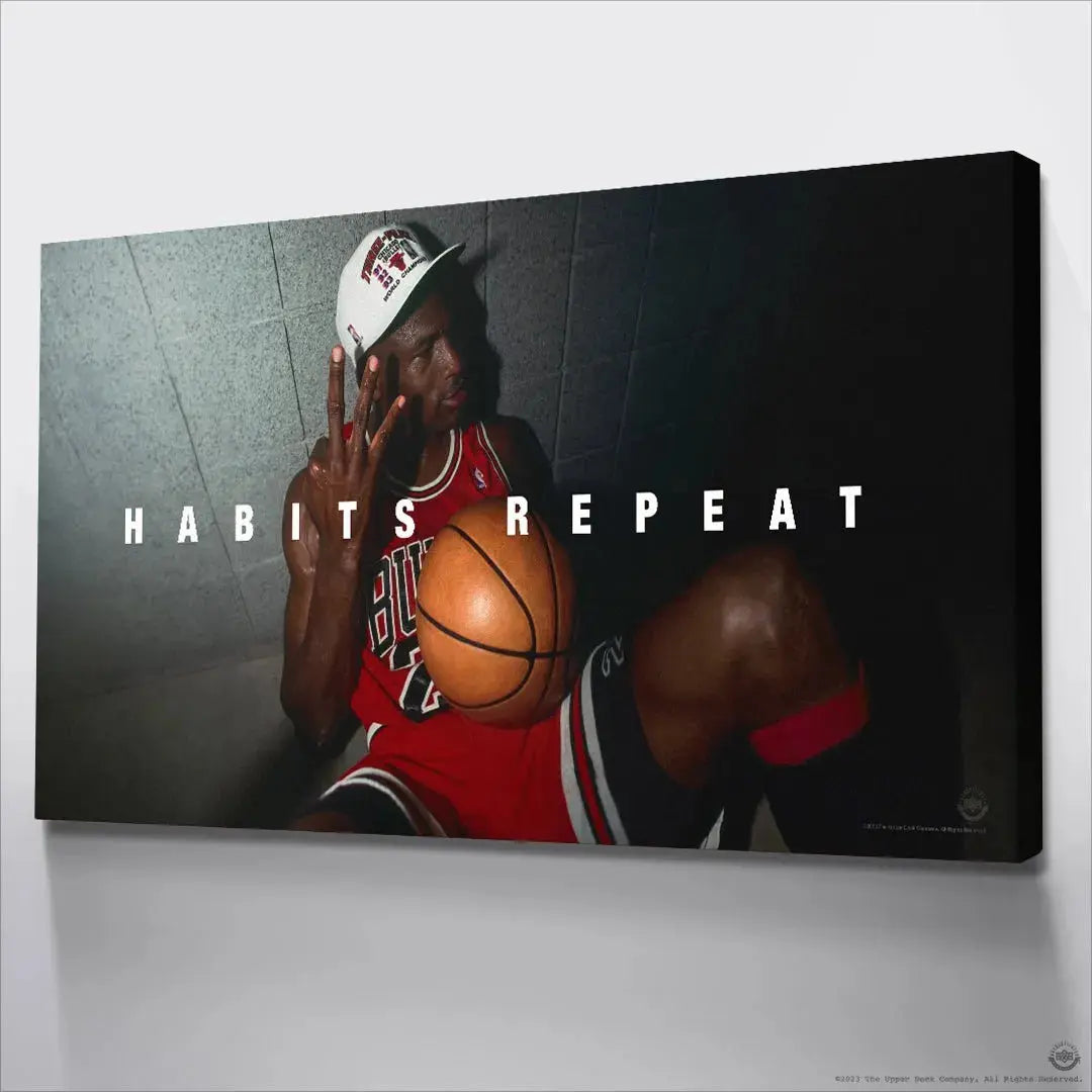 Low-angle perspective of Michael Jordan sitting against the wall celebrating success, captioned 'Michael Jordan - Habits Repeat'.