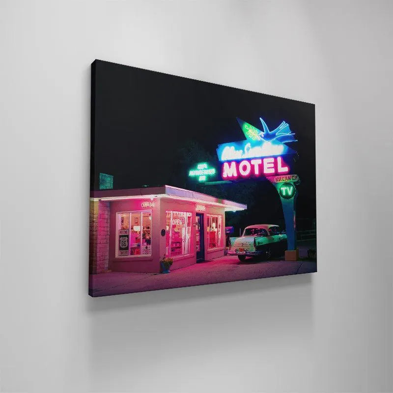 Classic 1950s automobile parked under the brilliant glow of the Blue Swallow Motel's Refrigerated Air advertisement sign.