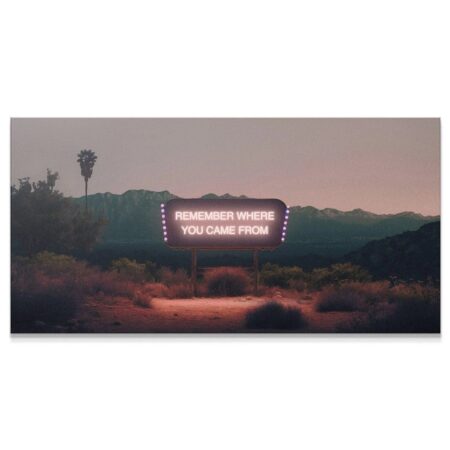Full panoramic view of the 'Remember Where You Came From' neon sign at sunset in the desert.