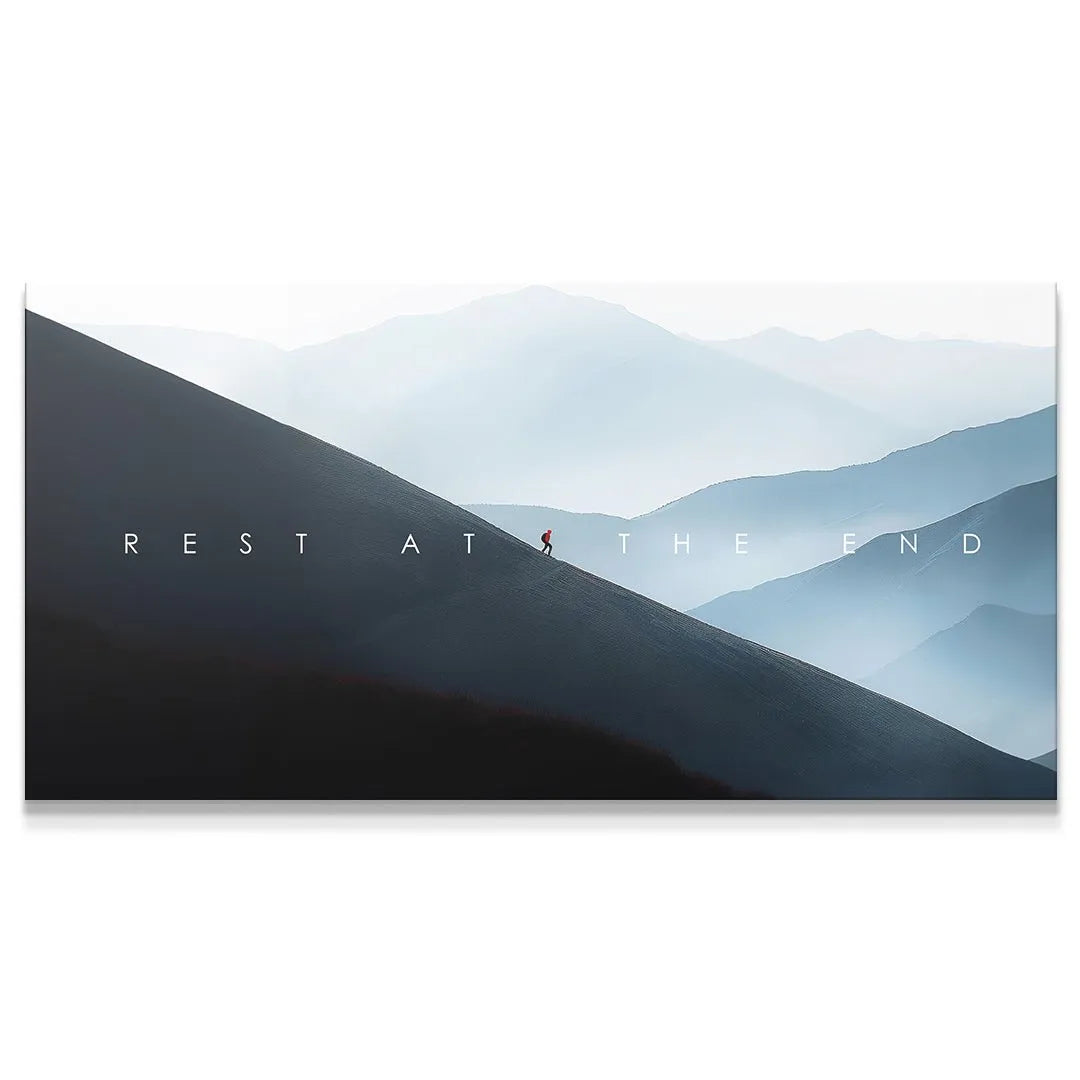 Panoramic landscape art showing a lone hiker on a steep dark slope with text 'Rest At The End'.