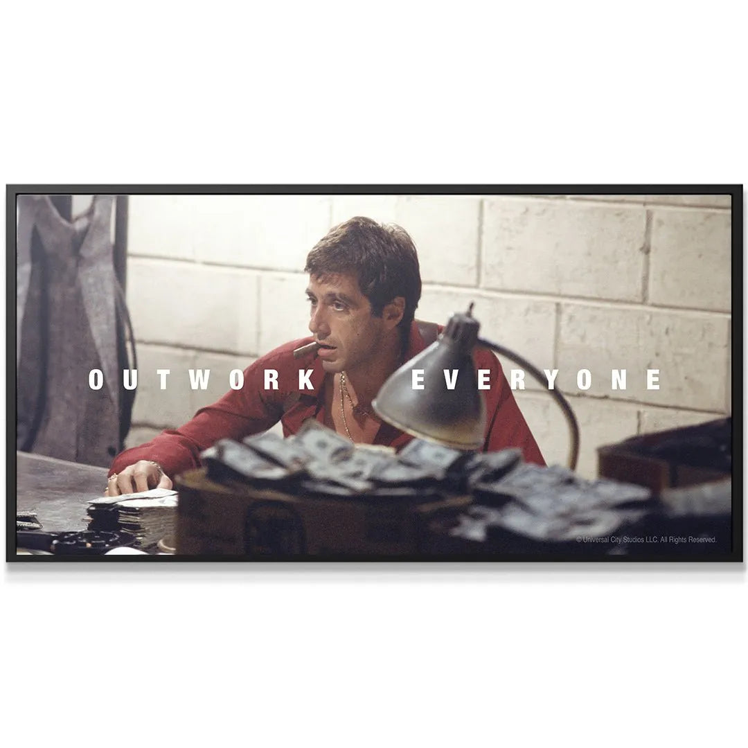 Detailed view of scattered money stacks and what appears to be a gun on the desk in the Scarface - Outwork Everyone motivational scene.