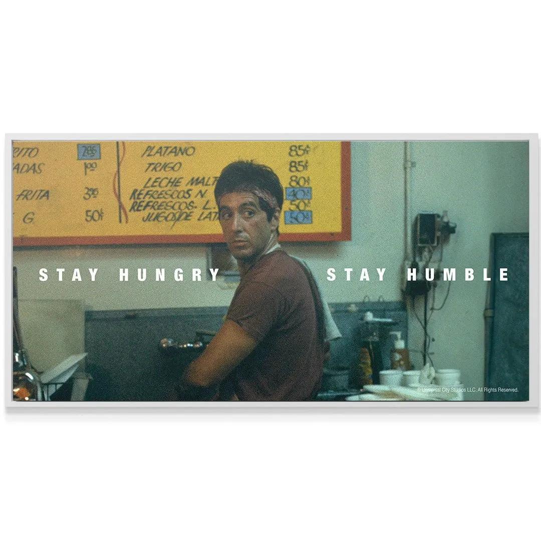 Lifestyle shot of the framed wall art displayed in a modern office, emphasizing the motivational quote 'Scarface - Stay Hungry, Stay Humble'.