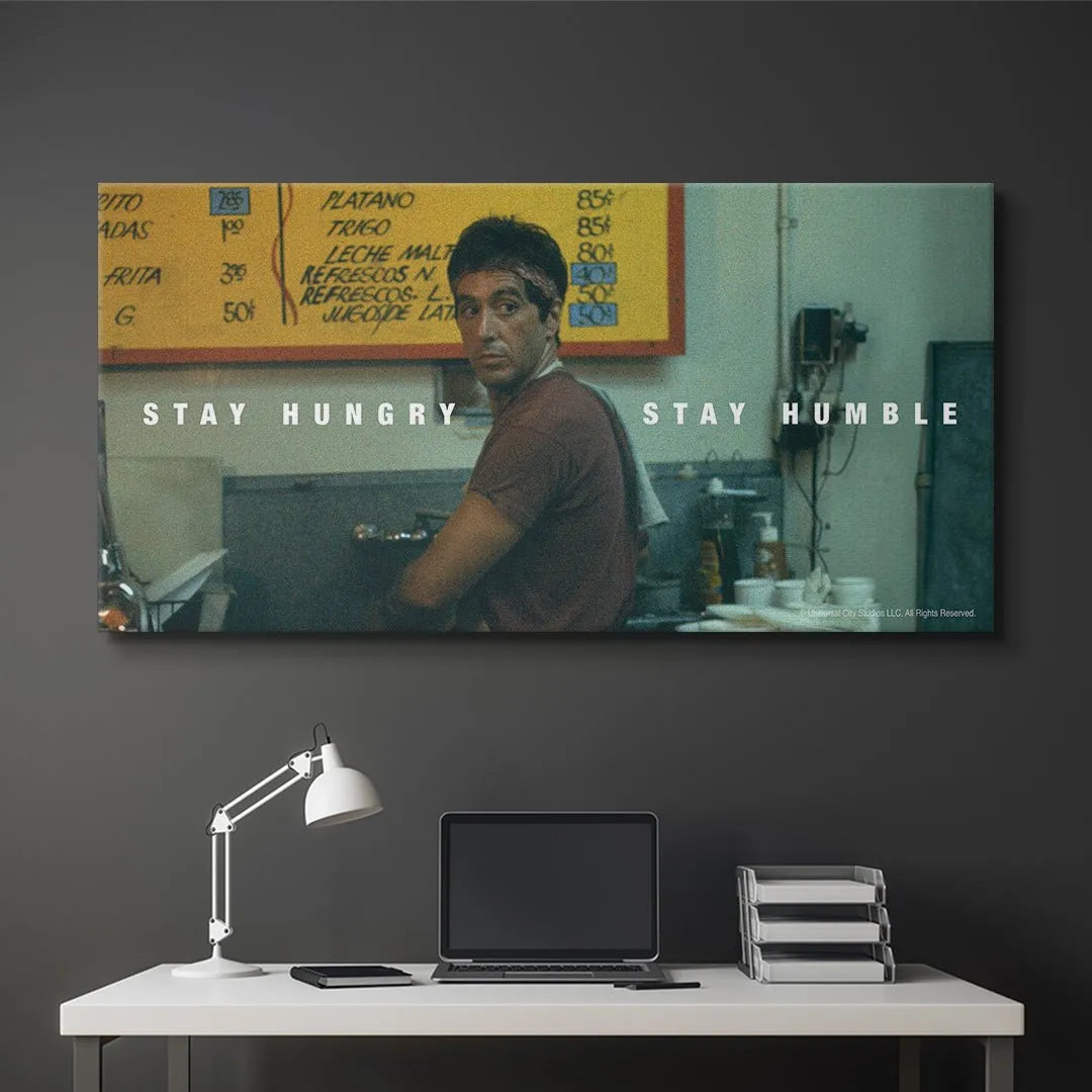 Wide angle shot showing the Cuban menu board and vintage restaurant setting in the background of the 'Scarface - Stay Hungry, Stay Humble' artwork.