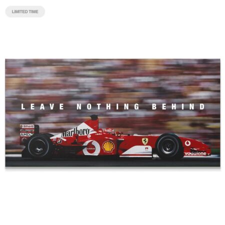 Full side profile of the red Ferrari F1 car accelerating, titled Schumacher - Leave Nothing Behind.