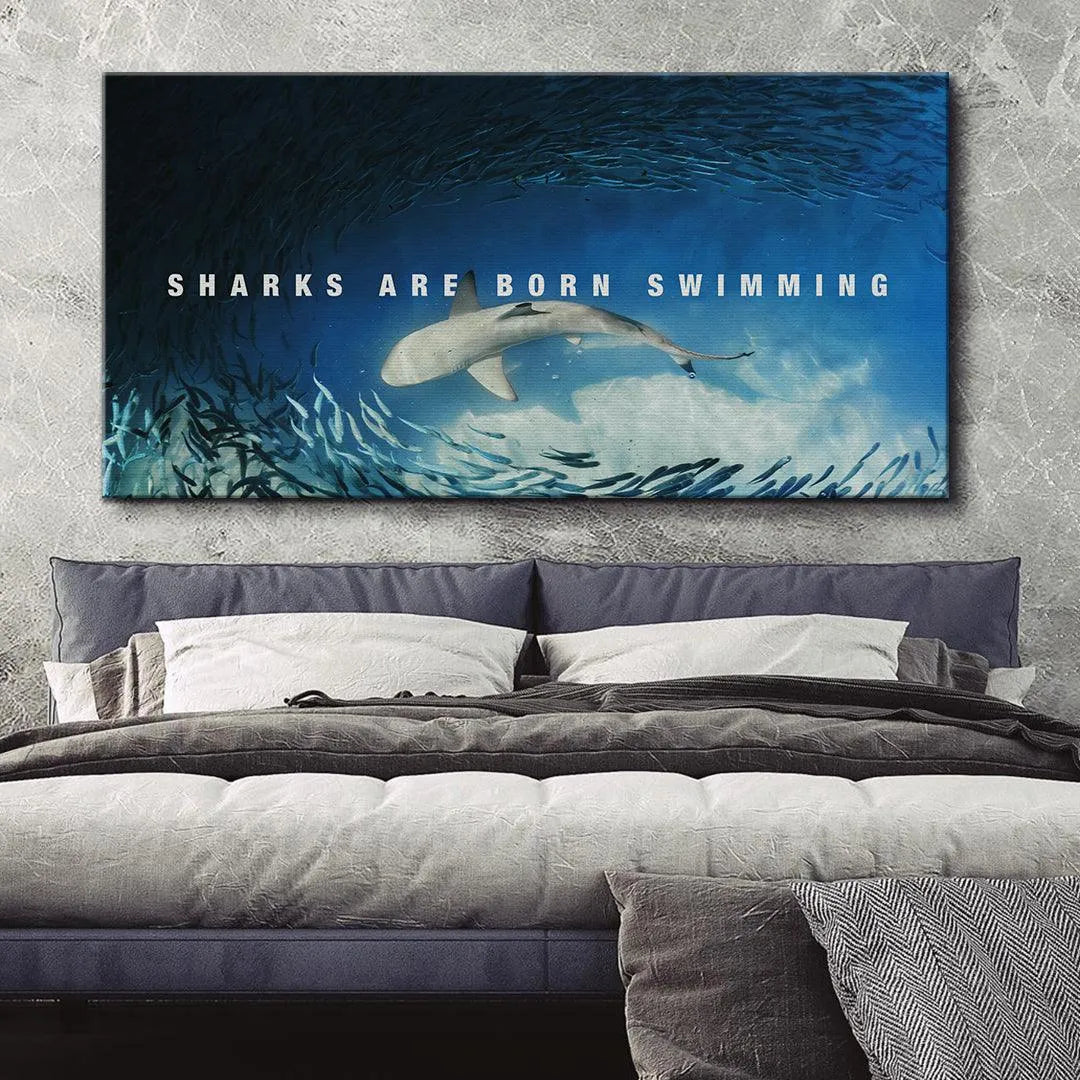 High-contrast angle of the shark's dorsal fin against the bright blue water, emphasizing 'Sharks Are Born Swimming' wall decor.
