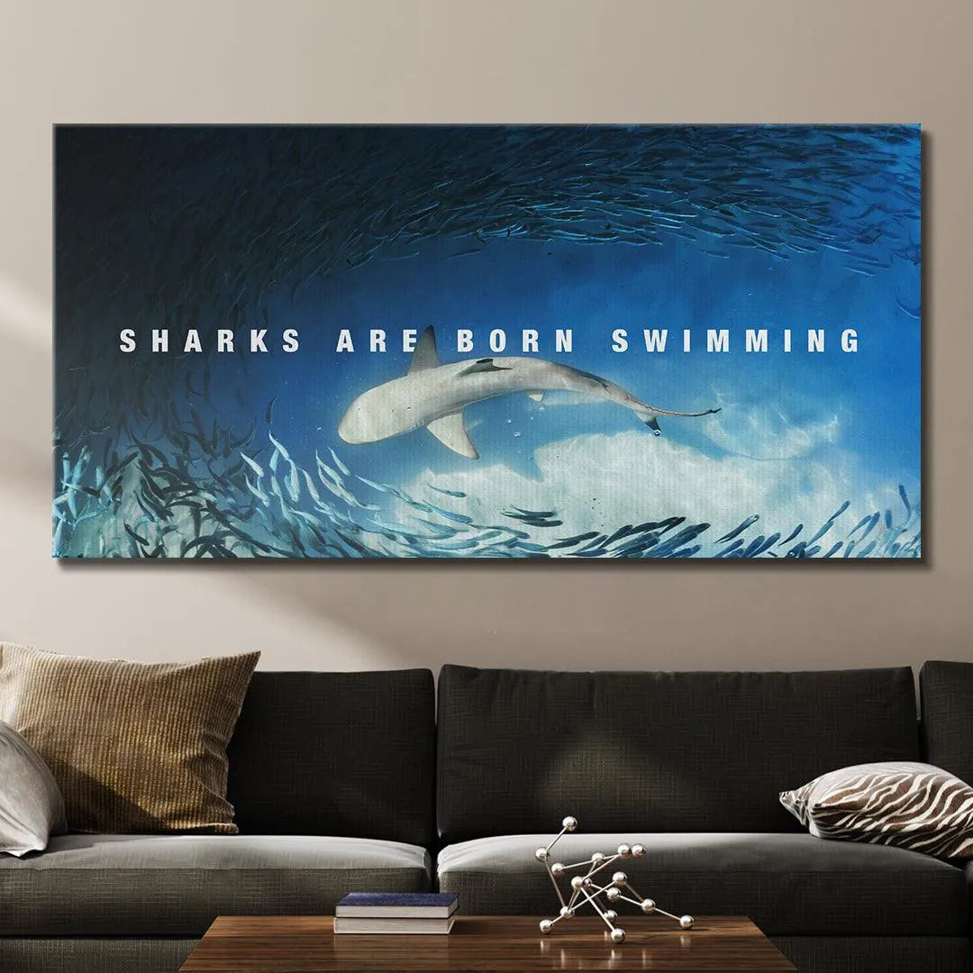 Longitudinal perspective photo of the entire motivational print that reads 'Sharks Are Born Swimming' on a modern wall display.