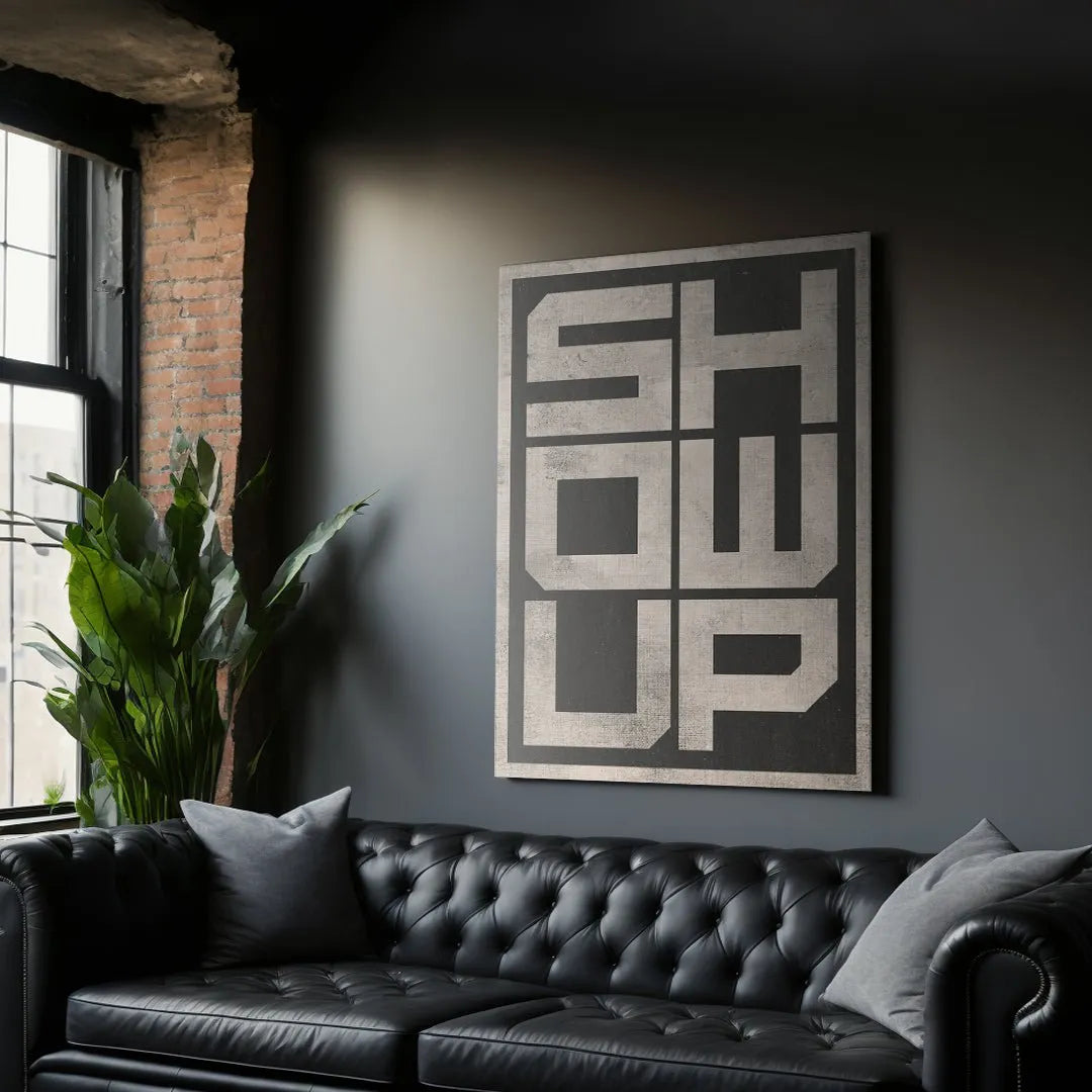 Lifestyle scene showing 'Show Up - 2' mounted above a contemporary minimalist desk setup.